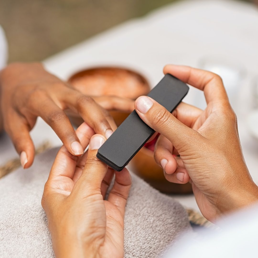woman-using-a-buffer-to-file-nail.jpg